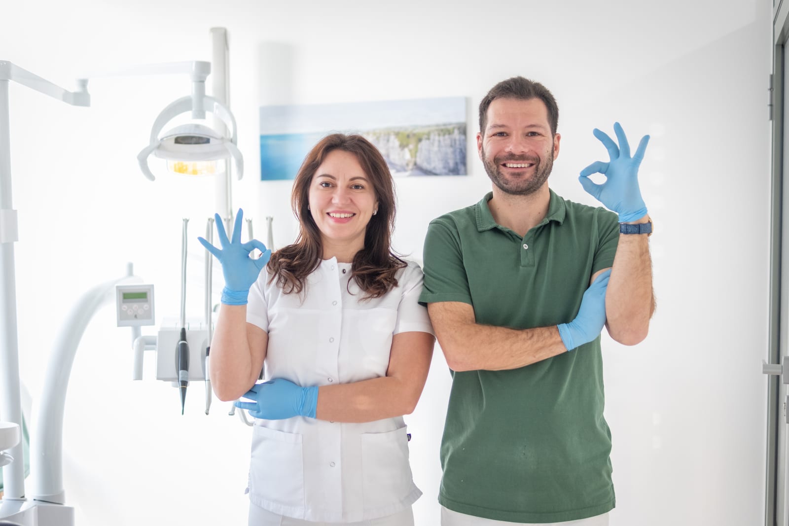 Deux membres de l'équipe du Cabinet Dentaire Côté Gare à Bussigny, souriants, gants bleus, dans une salle de soins